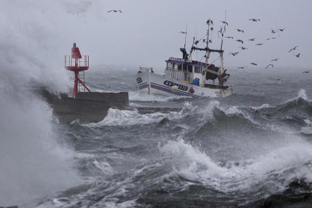 A fishing boat arrives at the port in Plobannalec-Lesconil, western France, October 22, 2025, as huge waves and strong winds hit the coast at the passage of the storm Benjamin. (Photo by Fred TANNEAU / AFP)