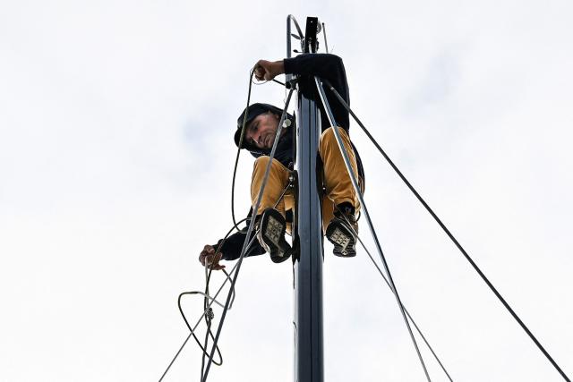French skipper Gilles Courbon works on the mast of Team Courbon's Class 40 monohull RDT Logistic - Forvis Mazars ahead of the start of the Transat Cafe l'OR (former Transat Jacques Vabre) duo sailing race from Le Havre to Fort-de-France, on October 22, 2025,  in Le Havre, northwestern France. The Transat Café L'OR 2025 ocean race is scheduled to start on October 26, 2025 from Le Havre, France and sail to the bay of Fort-de-France in Martinique. (Photo by LOU BENOIST / AFP) / ALTERNATE CROP