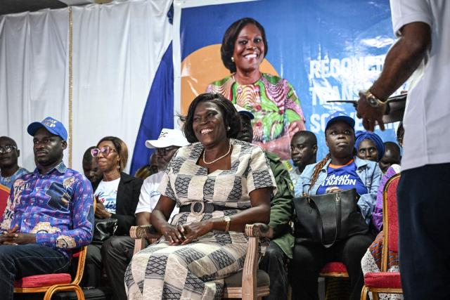 Former Ivorian First Lady and presidential candidate for the Movement of the Capable Generations (MGC), Simone Ehivet Gbagbo (C), looks on as he waits to address her supporters at her campaign rally in Barron, in the working-class commune of Yopougon in Abidjan on October 22, 2025. The presidential election is scheduled for October 25, 2025. (Photo by Sia KAMBOU / AFP)