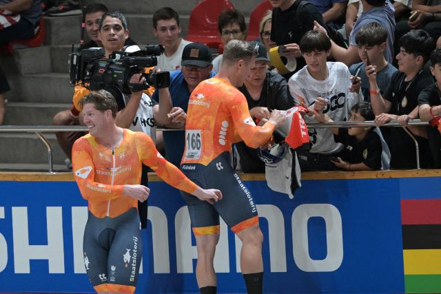 Netherlands' #166 Jeffrey Hoogland signs autographs after winning the men's team sprint final during the 2025 UCI Track World Championships at the Peñalolen Velodrome, in Santiago, on October 22, 2025. (Photo by Rodrigo ARANGUA / AFP)