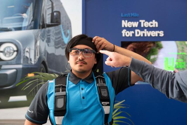 An Amazon delivery driver wears smart glasses displaying real-time navigation and delivery instructions directly in his field of vision, during Amazon's "Delivering the Future" presentation at DUR3 Delivery Station in Milpitas, California on October 22, 2025. (Photo by Laure Andrillon / AFP)