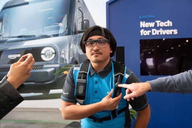 An Amazon delivery driver wears smart glasses displaying real-time navigation and delivery instructions directly in his field of vision, during Amazon's "Delivering the Future" presentation at DUR3 Delivery Station in Milpitas, California on October 22, 2025. (Photo by Laure Andrillon / AFP)