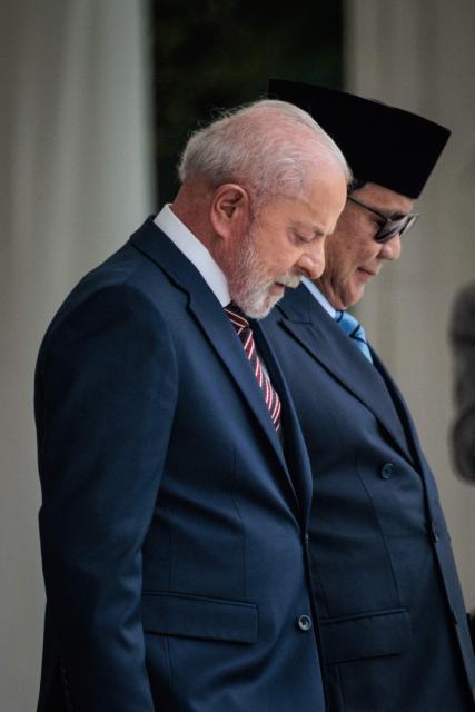 Brazil's President Luiz Inacio Lula da Silva (L) and Indonesia's President Prabowo Subianto walk to inspect an honour guard before their bilateral meeting at the presidential palace in Jakarta on October 23, 2025. (Photo by Yasuyoshi CHIBA / AFP)