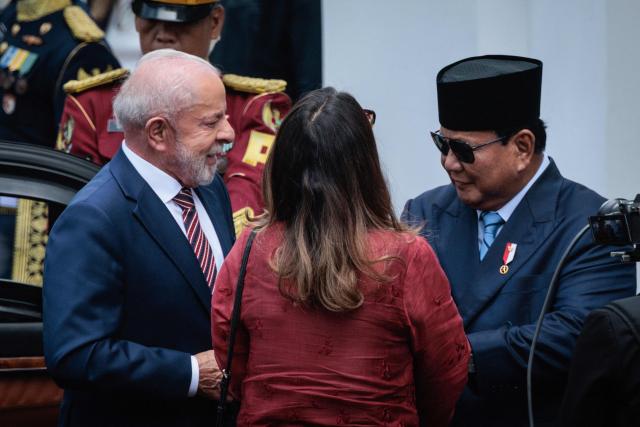 Brazil's President Luiz Inacio Lula da Silva (L) is welcomed by Indonesia's President Prabowo Subianto (R) upon his arrival at the presidential palace in Jakarta on October 23, 2025. (Photo by Yasuyoshi CHIBA / AFP)