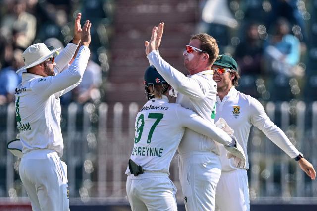 South Africa's Simon Harmer (2R) celebrates with teammates after taking the wicekt of Pakistan's Babar Azam during the fourth day of the second Test cricket match between Pakistan and South Africa at the Rawalpindi Cricket Stadium in Rawalpindi on October 23, 2025. (Photo by Aamir QURESHI / AFP)