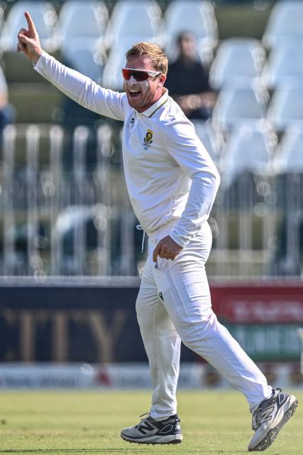 South Africa's Simon Harmer celebrates after taking the wicket of Pakistan's Babar Azam during the fourth day of the second Test cricket match between Pakistan and South Africa at the Rawalpindi Cricket Stadium in Rawalpindi on October 23, 2025. (Photo by Aamir QURESHI / AFP)