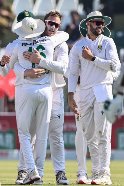 South Africa's Simon Harmer (C) celebrates with teammates after taking the wicket of Pakistan's Noman Ali during the fourth day of the second Test cricket match between Pakistan and South Africa at the Rawalpindi Cricket Stadium in Rawalpindi on October 23, 2025. (Photo by Aamir QURESHI / AFP)