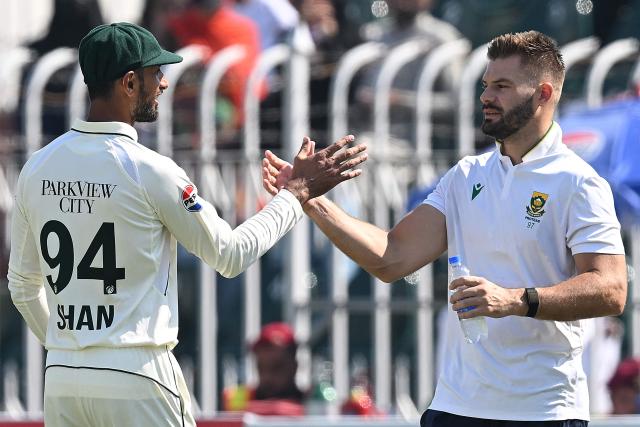 South Africa's Aiden Markram (R) shakes hands with his Pakistani counterpart Shan Masood at the end of the second Test cricket match between Pakistan and South Africa at the Rawalpindi Cricket Stadium in Rawalpindi on October 23, 2025. (Photo by Aamir QURESHI / AFP)