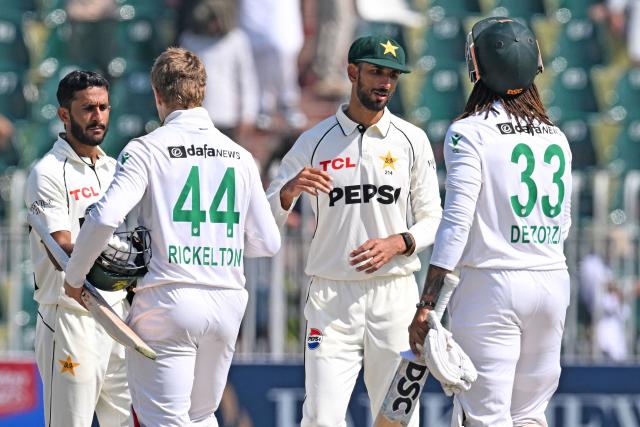 Pakistan's Shan Masood (2R) and his teammate Hasan Ali (L) shake hands with South Africa's Ryan Rickelton (2L) and Tony de Zorzi at the end of the second Test cricket match between Pakistan and South Africa at the Rawalpindi Cricket Stadium in Rawalpindi on October 23, 2025. (Photo by Aamir QURESHI / AFP)