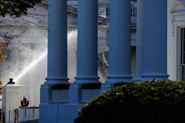 A worker talks on the phone near the North Portico of the White House in Washington, DC, on October 23, 2025, as demolition continues on the East Wing of the White House to make way for US President Donald Trumps White House ballroom. US President Donald Trump confirmed on October 22 that the White House's iconic East Wing is being torn down in its entirety to make way for a huge $300-million ballroom -- a far more extensive demolition than previously announced. Trump told reporters at an Oval Office event that he had decided after consulting architects that "really knocking it down" was preferable to a partial demolition. (Photo by Jim WATSON / AFP)