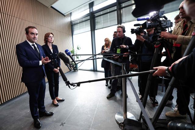 France's Prime Minister Sebastien Lecornu (L) flanked by France's Public Accounts Minister Amelie de Montchalin (R), speaks to the press during a visit at the National Tax Investigation Directorate (DNEF) and the National and International Audit Directorate (DVNI), in Romainville, in the outskirts of Paris, on October 23, 2025. (Photo by Thibaud MORITZ / POOL / AFP)