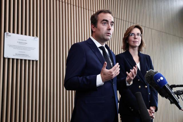 France's Prime Minister Sebastien Lecornu (L) flanked by France's Public Accounts Minister Amelie de Montchalin (R), speaks to the press during a visit at the National Tax Investigation Directorate (DNEF) and the National and International Audit Directorate (DVNI), in Romainville, in the outskirts of Paris, on October 23, 2025. (Photo by Thibaud MORITZ / POOL / AFP)