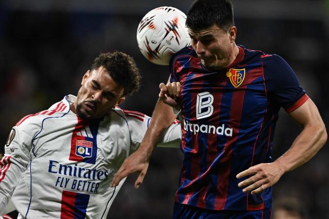 Lyon’s Dutch defender #21 Ruben Kluivert (L) fights for the ball with Bale’s Austrian defender #24 Flavius Daniliuc (R) during the UEFA Europa League first round day 3 football match between Olympique Lyonnais and FC Basel at the Groupama Stadium in Decines Charpieu, near Lyon, on October 23, 2025. (Photo by JEFF PACHOUD / AFP)