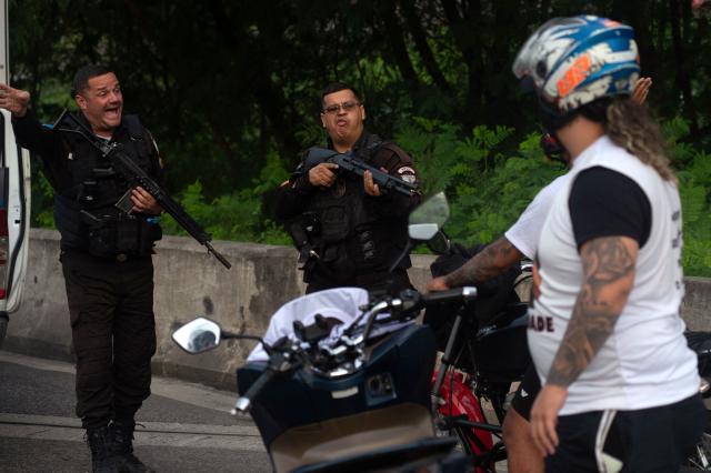(FILES) Police officers disperse MC Poze do Rodo fans after his release from Bangu 3 prison in of Rio de Janeiro, Brazil on June 3, 2025. The governor of the state of Rio de Janeiro, Claudio Castro, vetoed on October 23, 2025 a controversial measure that established the payment of bonuses to civil police officers for killing criminals, a proposal that sparked outrage in Brazil. (Photo by TERCIO TEIXEIRA / AFP)