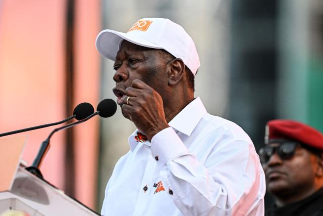 Ivorian President and presidential candidate for the Rally of Houphouetists for Democracy and Peace (RHDP), Alassane Ouattara (C) speaks during his closing campaign rally for the presidential election at the Place de la Republique, in the business district of Abidjan on October 23, 2025. The presidential election is scheduled for October 25, 2025. (Photo by Sia KAMBOU / AFP)