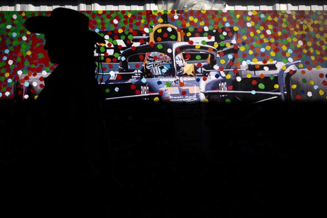A woman walks past a mural of Mexican driver Sergio Perez ahead of the Mexico City Formula One Grand Prix at the Hermanos Rodriguez racetrack in Mexico City on October 23, 2025. (Photo by Carl DE SOUZA / AFP)