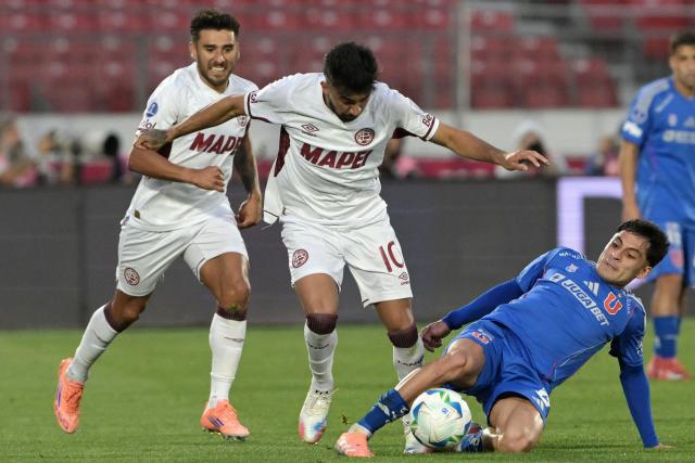 Lanus' midfielder #10 Marcelino Moreno and Universidad de Chile's midfielder #19 Javier Altamirano fight for the ball during the Copa Sudamericana semifinal first leg football match between Chile's Universidad de Chile and Argentina's Lanus at the Nacional Julio Martinez Pradanos stadium in Santiago on October 23, 2025. (Photo by Rodrigo ARANGUA / AFP)