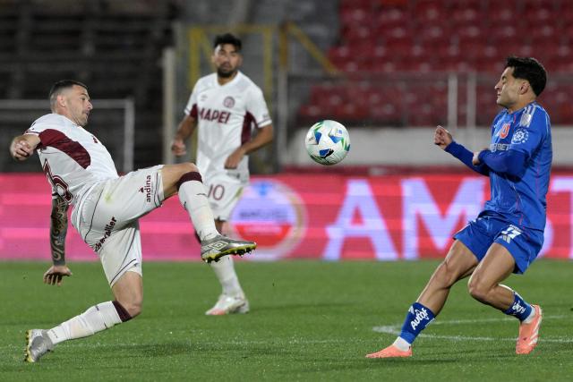 Lanus' defender #13 Jose Maria Canale and Universidad de Chile's midfielder #19 Javier Altamirano fight for the ball during the Copa Sudamericana semifinal first leg football match between Chile's Universidad de Chile and Argentina's Lanus at the Nacional Julio Martinez Pradanos stadium in Santiago on October 23, 2025. (Photo by Rodrigo ARANGUA / AFP)