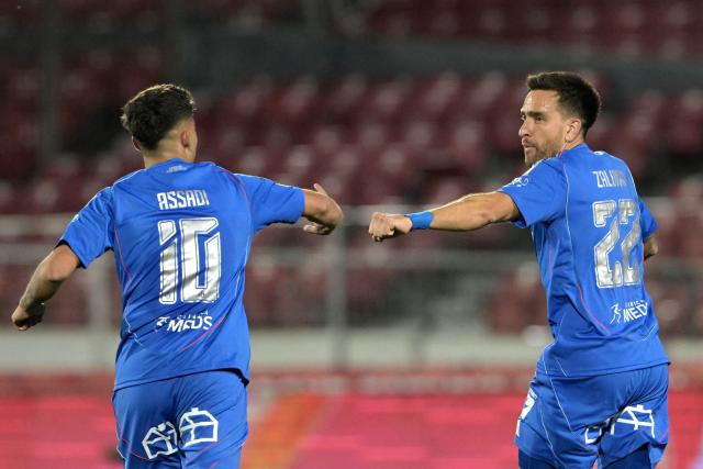 Universidad de Chile's forward #10 Lucas Assadi and teammate defender #22 Matias Zaldivia celebrate the first goal of their team during the Copa Sudamericana semifinal first leg football match between Chile's Universidad de Chile and Argentina's Lanus at the Nacional Julio Martinez Pradanos stadium in Santiago on October 23, 2025. (Photo by Rodrigo ARANGUA / AFP)