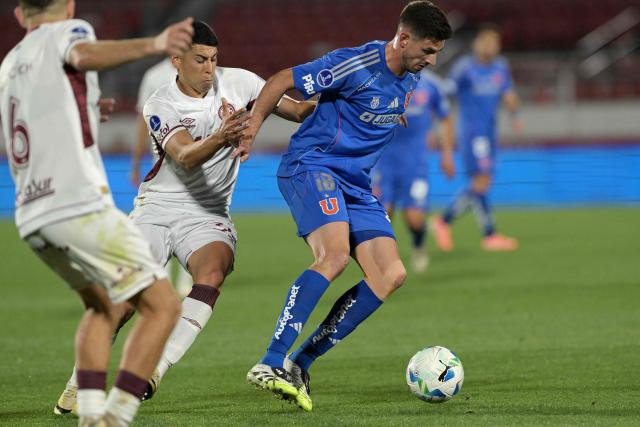 Lanus' midfielder #30 Agustin Cardozo and Universidad de Chile's Argentine forward #18 Lucas Di Yorio fight for the ball during the Copa Sudamericana semifinal first leg football match between Chile's Universidad de Chile and Argentina's Lanus at the Nacional Julio Martinez Pradanos stadium in Santiago on October 23, 2025. (Photo by Rodrigo ARANGUA / AFP)