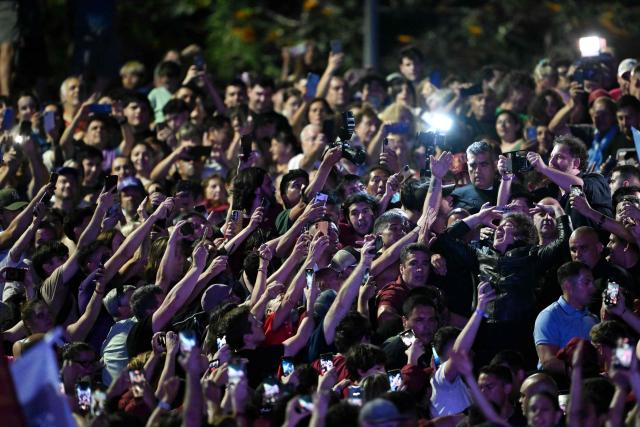 Argentina's President Javier Milei (R) greets supporters during the closing campaign rally of Libertad Avanza party ahead of the upcoming legislative elections in Rosario, Santa Fe province, Argentina on October 23, 2025. Milei, once a global poster boy for budget-slashing libertarian politics, is heading into the polls diminished by his failure to stabilize Argentina's ailing peso despite spending nearly all the Central Bank's dollar reserves to prop it up. (Photo by Luis ROBAYO / AFP)