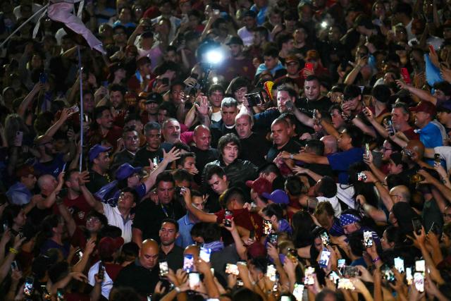 Argentina's President Javier Milei (C) greets supporters as he arrives to the closing campaign rally of Libertad Avanza party ahead of the upcoming legislative elections in Rosario, Santa Fe province, Argentina on October 23, 2025. Milei, once a global poster boy for budget-slashing libertarian politics, is heading into the polls diminished by his failure to stabilize Argentina's ailing peso despite spending nearly all the Central Bank's dollar reserves to prop it up. (Photo by Luis ROBAYO / AFP)