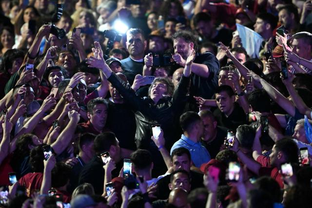 Argentina's President Javier Milei (C) greets supporters as he arrives to the closing campaign rally of Libertad Avanza party ahead of the upcoming legislative elections in Rosario, Santa Fe province, Argentina on October 23, 2025. Milei, once a global poster boy for budget-slashing libertarian politics, is heading into the polls diminished by his failure to stabilize Argentina's ailing peso despite spending nearly all the Central Bank's dollar reserves to prop it up. (Photo by Luis ROBAYO / AFP)