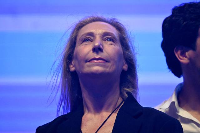 Argentina's Secretary General of the Presidency Karina Milei looks at her brother, President Javier Milei (out of frame), arriving at the closing campaign rally of Libertad Avanza party ahead of the upcoming legislative elections in Rosario, Santa Fe province, Argentina on October 23, 2025. Milei, once a global poster boy for budget-slashing libertarian politics, is heading into the polls diminished by his failure to stabilize Argentina's ailing peso despite spending nearly all the Central Bank's dollar reserves to prop it up. (Photo by Luis ROBAYO / AFP)