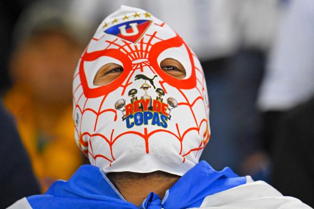 A fan of Liga Deportiva de Quito wearing a mask of the comic character Spiderman looks on ahead of the Copa Libertadores semifinal first leg football match between Ecuador's Liga de Quito and Brazil's Palmeiras at the Rodrigo Paz Delgado stadium in Quito on October 23, 2025. (Photo by Rodrigo BUENDIA / AFP)