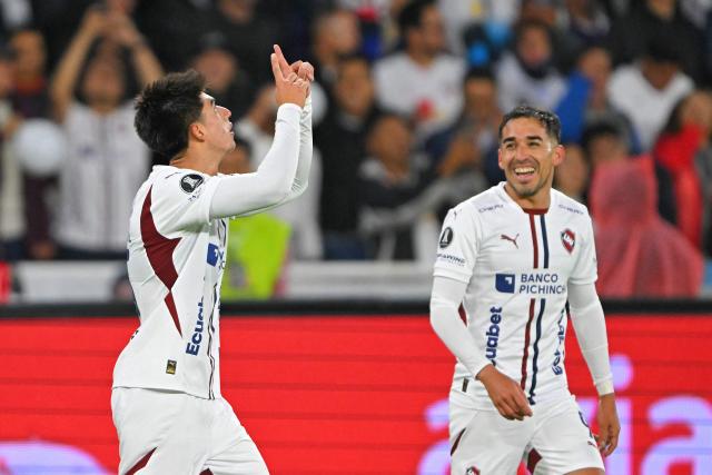 Liga de Quito's Bolivian midfielder #15 Gabriel Villamil (L) celebrates scoring his team's third goal during the Copa Libertadores semifinal first leg football match between Ecuador's Liga de Quito and Brazil's Palmeiras at the Rodrigo Paz Delgado stadium in Quito on October 23, 2025. (Photo by Rodrigo BUENDIA / AFP)