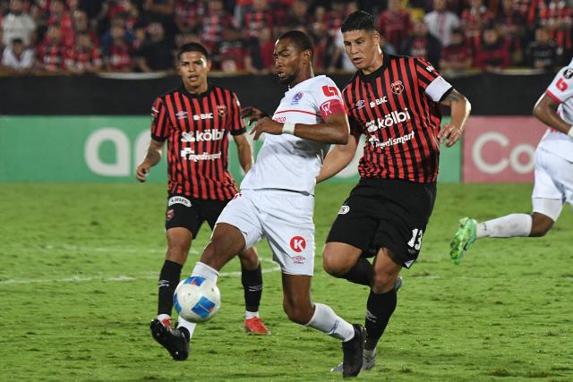 Olimpia's forward #27 Jerry Bengtson and Alajuelense's defender #13 Alexis Gamboa fight for the ball during the CONCACAF Central American Cup semifinal first leg football match between Costa Rica's Alajuelense and Honduras's Olimpia at the Alejandro Morera Soto Stadium in Alajuela, Costa Rica on October 23, 2025. (Photo by EZEQUIEL BECERRA / AFP)