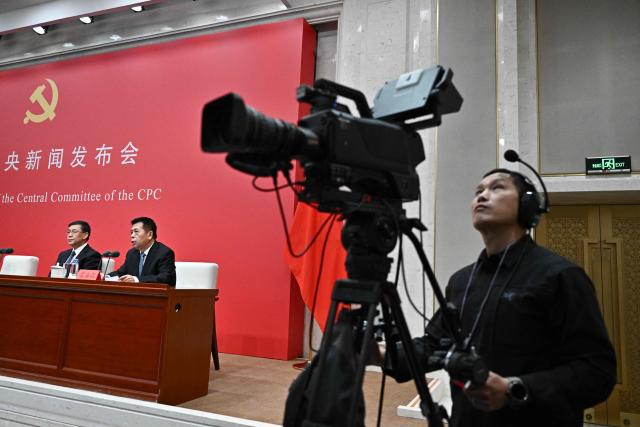 Minister of Science and Technology Yin Hejun (L) and Minister of the National Health Commission Lei Haichao (2nd L-R) attend a press conference of the Central Committee of the Communist Party of China (CPC) in Beijing on October 24, 2025. (Photo by Pedro PARDO / AFP)