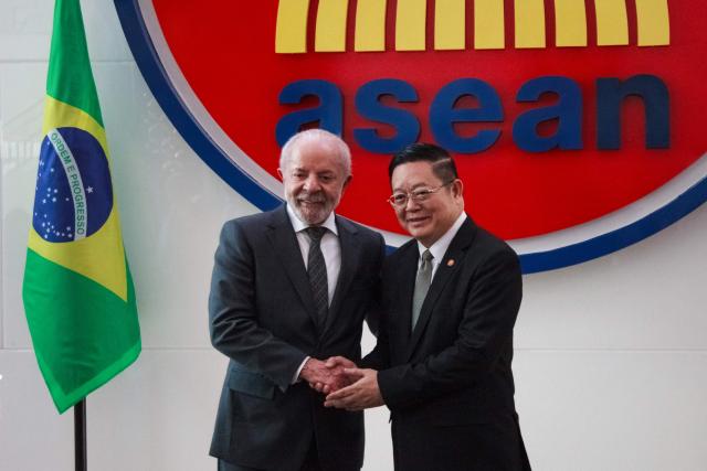 Brazil's President Luiz Inacio Lula da Silva (L) poses with Secretary General of the Association of Southeast Asian Nations (ASEAN) Kao Kim Hourn upon his arrival at the ASEAN Secretariat in Jakarta on October 24, 2025. (Photo by Aditya IRAWAN / AFP)