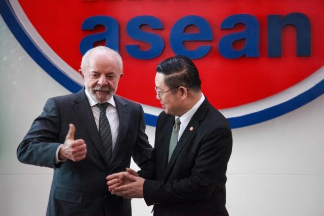 Brazil's President Luiz Inacio Lula da Silva (L) poses with Secretary General of the Association of Southeast Asian Nations (ASEAN) Kao Kim Hourn upon his arrival at the ASEAN Secretariat in Jakarta on October 24, 2025. (Photo by Aditya IRAWAN / AFP)