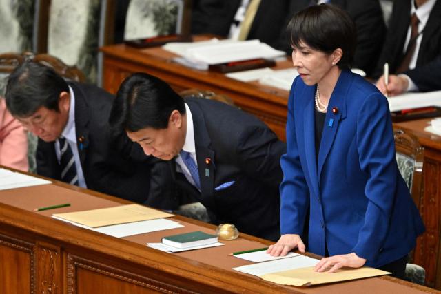 Japan's Prime Minister Sanae Takaichi (R) leaves after delivering her policy speech in the House of Representatives plenary session in Tokyo on October 24, 2025. Japan's new prime minister Sanae Takaichi said on October 24 she would try to achieve the country's target of spending two percent of GDP on defence two years early. (Photo by Kazuhiro NOGI / AFP)