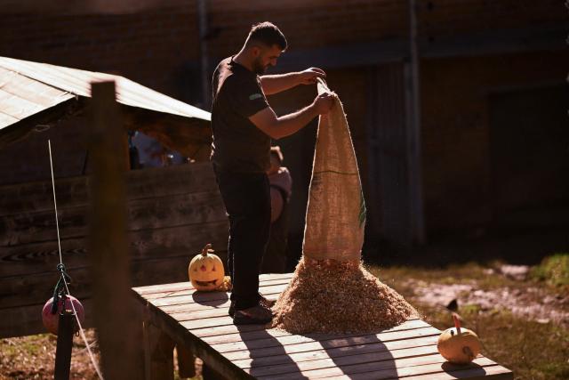 A worker prepares treats for brown bears at the Bear Sanctuary near Pristina on October 24, 2025. (Photo by Armend NIMANI / AFP)