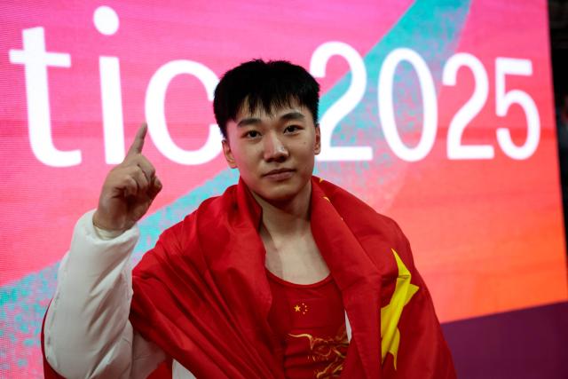 China’s Hong Yanming poses after winning the men's pommel horse final at the 53rd FIG Artistic Gymnastics World Championships in Jakarta on October 24, 2025. (Photo by Yasuyoshi CHIBA / AFP)