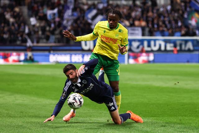 Paris FC's French midfielder #33 Pierre Lees-Melou (down) fights for the ball with Nantes' French Congolese midfielder #80 Junior Mwanga during the French L1 football match between Paris FC and FC Nantes at the Stade Jean-Bouin in Paris on October 24, 2025. (Photo by FRANCK FIFE / AFP)