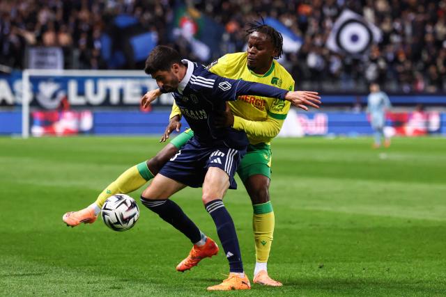 Paris FC's French midfielder #33 Pierre Lees-Melou (L) fights for the ball with Nantes' French Congolese midfielder #80 Junior Mwanga during the French L1 football match between Paris FC and FC Nantes at the Stade Jean-Bouin in Paris on October 24, 2025. (Photo by FRANCK FIFE / AFP)