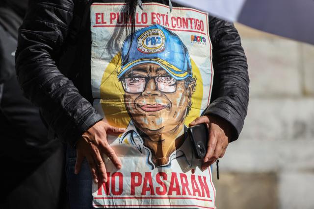 A supporter holds an image depicting Colombia's President Gustavo Petro during a rally in his support at Bolivar Square in Bogota on October 24, 2025. US on Friday announced sanctions on Colombia's President Gustavo Petro, who Washington has accused of failing to curb illicit drug trafficking, alongside his wife and eldest son. (Photo by JOHN VIZCAINO / AFP)
