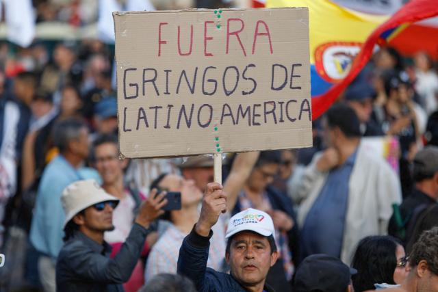 A demonstrator holds a sign reading "Gringos out of Latin America" during a rally called by Colombia's President Gustavo Petro at Bolivar Square in Bogota on October 24, 2025. US on Friday announced sanctions on Colombia's President Gustavo Petro, who Washington has accused of failing to curb illicit drug trafficking, alongside his wife and eldest son. (Photo by John Vizcaino / AFP)