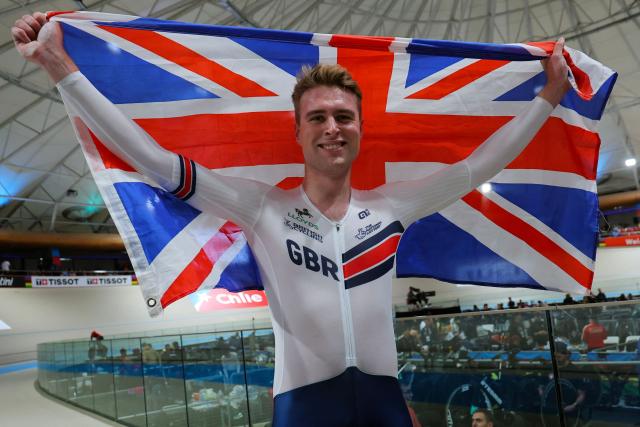 Great Britain's  #118 Josh Charlton celebrates with a British flag after winnng the men's individual pursuit event final at the 2025 UCI Track World Championships, in the Penalolen Velodrome in Santiago, on October 24, 2025. (Photo by Javier TORRES / AFP)