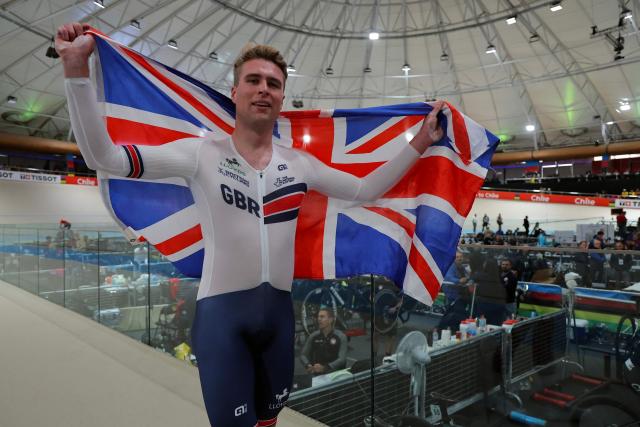 Great Britain's  #118 Josh Charlton celebrates with a British flag after winnng the men's individual pursuit event final at the 2025 UCI Track World Championships, in the Penalolen Velodrome in Santiago, on October 24, 2025. (Photo by Javier TORRES / AFP)