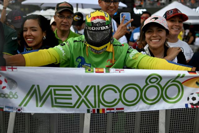 A fan wearing a costume helmet cheers during the second practice session of the Mexico City Formula One Grand Prix at the Hermanos Rodriguez racetrack in Mexico City on October 24, 2025. (Photo by Carl DE SOUZA / AFP)