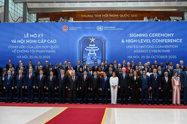 Delegates pose for photos at the signing ceremony of the United Nations Convention against Cybercrime at the National Convention Center in Hanoi on October 25, 2025. (Photo by Nhac NGUYEN / AFP)