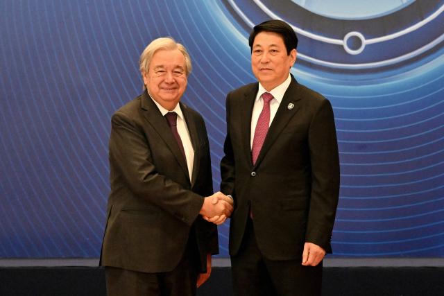 Vietnam's President Luong Cuong (R) shakes hands with United Nations Secretary General Antonio Guterres at the signing ceremony of the United Nations Convention against Cybercrime at the National Convention Center in Hanoi on October 25, 2025. (Photo by Nhac NGUYEN / AFP)