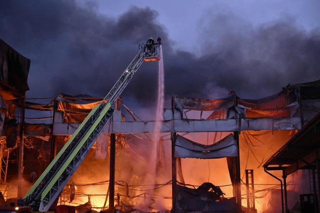 Ukrainian firefighters extinguish a fire at the site of a food warehouse following a Russian missile strike in Kyiv early on October 25, 2025, amid the Russian invasion of Ukraine. (Photo by Genya SAVILOV / AFP)
