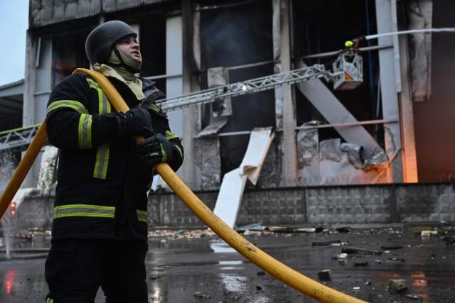 Ukrainian firefighters extinguish a fire at the site of a food warehouse following a Russian missile strike in Kyiv early on October 25, 2025, amid the Russian invasion of Ukraine. (Photo by Genya SAVILOV / AFP)