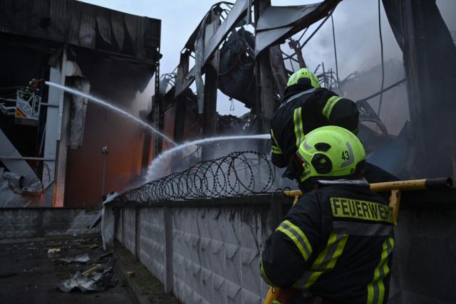 Ukrainian firefighters extinguish a fire at the site of a food warehouse following a Russian missile strike in Kyiv early on October 25, 2025, amid the Russian invasion of Ukraine. (Photo by Genya SAVILOV / AFP)