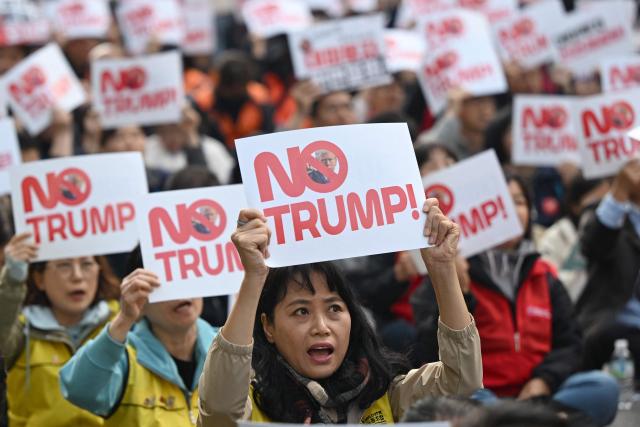 Protesters hold up signs reading "No Trump!" during a rally, condemning US President Donald Trump's pressure for increased South Korean investment in the US, in Seoul on October 25, 2025. Trump headed for Asia on October 25 and high-stakes trade talks with Chinese counterpart Xi Jinping, saying that he would also like to meet North Korean leader Kim Jong Un on his trip. (Photo by Jung Yeon-je / AFP)